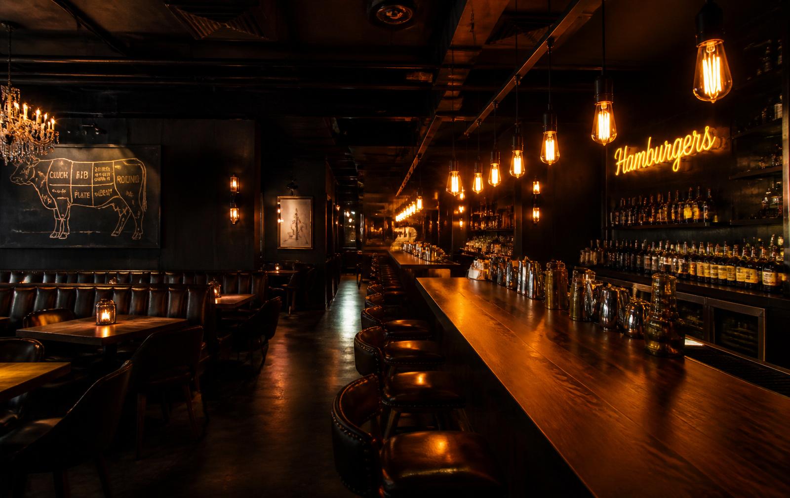 Interior da Dunkel Burger, ambiente escuro e sofisticado com iluminação âmbar